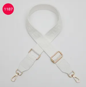Adjustable wide replacement bag strap in solid white with chic geometric pattern and gold hardware.
