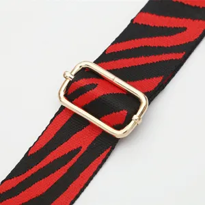 Wide replacement bag strap with red and black zebra pattern and adjustable gold metal buckle.