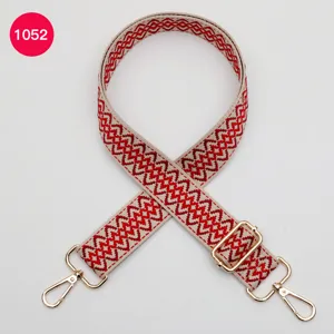 Adjustable woven replacement shoulder strap for crossbody bags with gold metal hardware details.