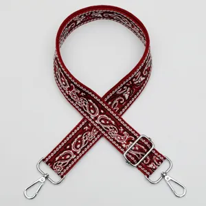 Bandoulière de sac large réglable avec motif cachemire rouge et accessoires métalliques.