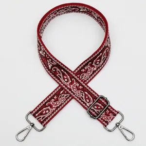 Vue détaillée de la large sangle de sac jacquard ethnique rouge avec crochets en métal.