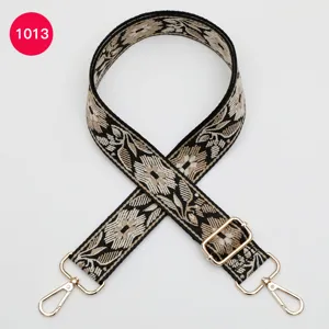 Detailed view of the ethnic floral jacquard bag strap with golden hardware hooks and buckle.
