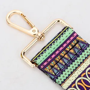 Ethnic style wide bag strap replacement with colorful geometric pattern and gold metal hardware.