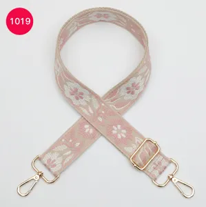 Detail view of colorful ethnic floral jacquard wide bag strap replacement accessory with gold hardware.