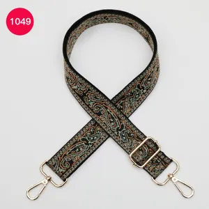 Détail de bandoulière tissée ethnique avec motif cache-mire coloré et crochets métalliques.