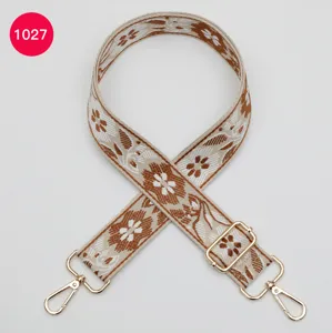 Detail shot of the woven ethnic floral bag strap, showing intricate jacquard pattern and gold hardware.