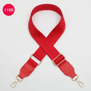 Vue détaillée de la bandoulière rouge réglable avec motif jacquard losange et doré.