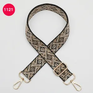 Détail de la sangle de sac tissée jacquard, bandoulière réglable avec accessoires dorés.