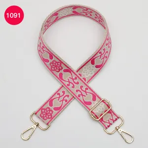 Ethnic jacquard wide bag strap replacement with pink floral pattern and gold metal hardware.