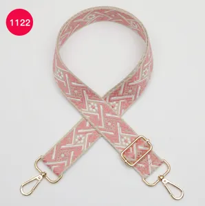 Vue détaillée de la sangle de sac tissée de rechange avec motif jacquard géométrique rose et métal.