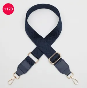 Bandoulière de sac tissée bleu foncé avec motif en losange et bouclerie dorée réglable.