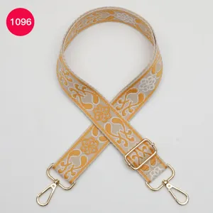 Detailed close-up of ethnic style jacquard wide bag strap with premium golden metal hardware.