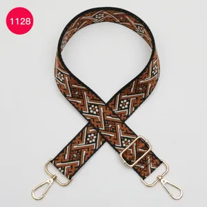 Détail de sangle de sac de rechange tissée avec motif ethnique et crochets en métal doré.