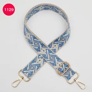Vue détaillée d'une lanière de sac de rechange en jacquard bleu et blanc avec quincaillerie dorée.