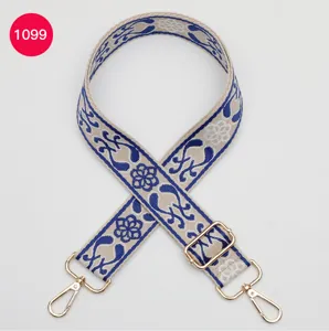 Ethnic style woven wide bag strap featuring blue floral pattern and premium gold hardware.
