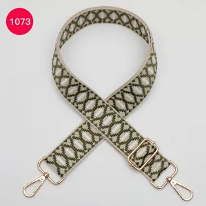 Gedetailleerd overzicht van groene geometrisch geweven tasriem met gouden metalen hardware.