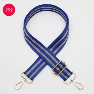 Adjustable wide replacement bag strap with blue and grey striped webbing and gold metal hardware.