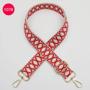 Vervangende tasriem met rood geometrisch jacquard patroon en verstelbare gouden metalen haken.