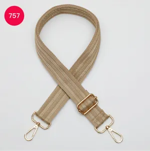 Detailed view of wide adjustable webbing bag strap with luxury gold hardware and hooks.