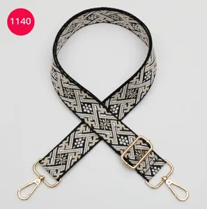 Gros plan détaillé de la sangle de sac jacquard réglable avec des clips en métal doré.