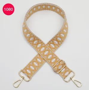 Jacquard tasriem detail, geel-witte gewoven geometrische patroon met gouden metalen beslag.