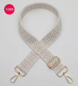 Verstelbare vervangende tassenriem detail met geometrisch jacquard patroon en gouden hardware.