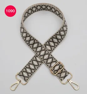 Vervangende tasband met geometrisch jacquard-patroon en verstelbare gouden metalen hardware.