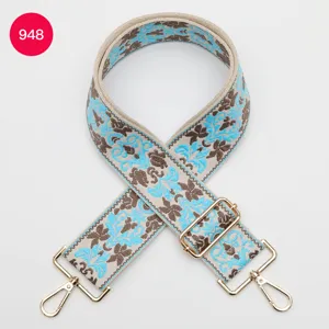 Wide jacquard bag strap with ethnic floral pattern, adjustable design with gold hardware.