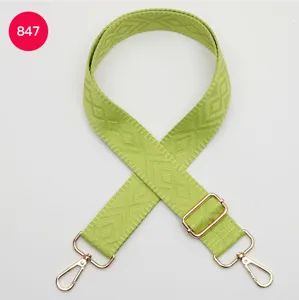 Tracolla per borsa in tessuto verde con motivo a rombi e dettagli in metallo dorato lucido.