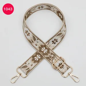 Ethnic style woven wide bag strap detail, floral jacquard design with gold metal hooks.