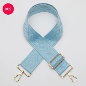 Détail de sangle de sac de remplacement tissée en bleu clair avec boucles dorées.