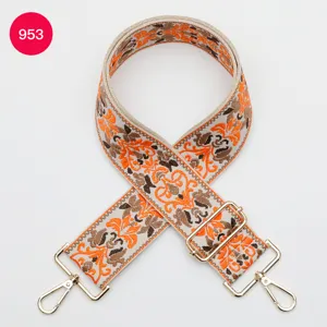 Close-up of ethnic jacquard bag strap detail with golden hardware and colorful embroidery.