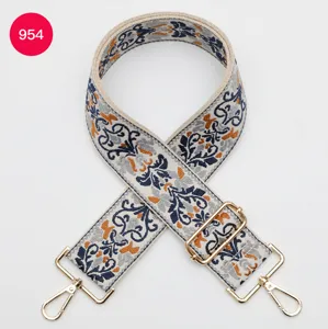 Close-up of ethnic jacquard wide strap with metallic hardware and intricate geometric pattern.