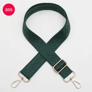 Primo piano della tracolla di ricambio verde scuro per borsa con motivo geometrico e parti dorate.