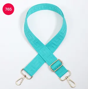 Adjustable turquoise bag strap with geometric labyrinth pattern and gold metal hardware.
