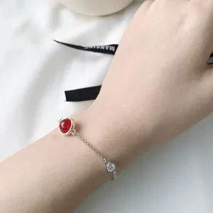 Nahaufnahme Detail des Silberarmbands mit roter Achatperle und funkelndem Zirkoniastein.