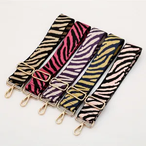 Adjustable wide replacement bag strap with zebra pattern and gold metal hardware.