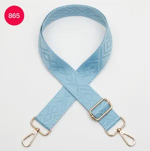 Tracolla per borsa intrecciata azzurra con hardware dorato regolabile e motivo geometrico elegante.