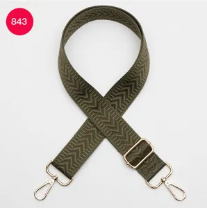 Détail de sangle de sac tissée verte, bandoulière de rechange à motif chevron avec crochets en métal.