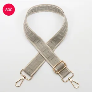 Adjustable wide replacement bag strap with Greek key woven pattern and gold tone hardware.