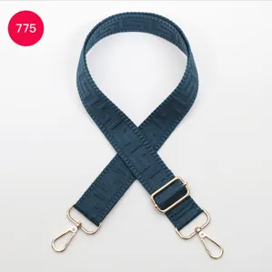 Detailed view of adjustable geometric pattern replacement bag strap with gold metal hardware.