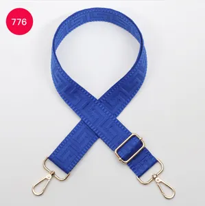 Adjustable blue bag strap with golden hardware and geometric maze pattern for crossbody bags.