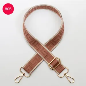 Detailed view of a wide adjustable crossbody bag strap featuring pink beige maze pattern and gold hardware.
