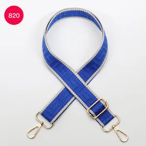 Adjustable blue and grey patterned wide bag strap with gold hardware for crossbody bags.
