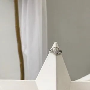 Gros plan bague chaîne argentée, bague ouverte rétro avec pierre blanche scintillante.