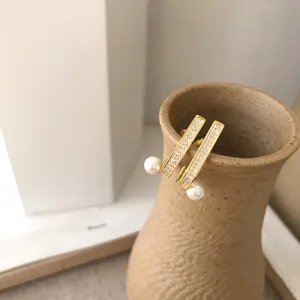 Gros plan détaillé de boucles d'oreilles élégantes en perles et zircons scintillants.