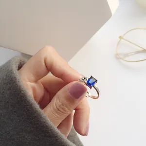 Gros plan d'une bague ouverte en argent vintage avec pierre bleue et détails gravés main.