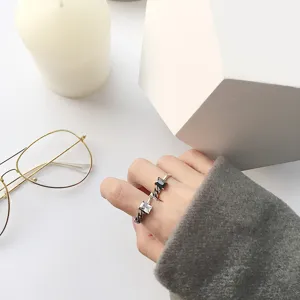 Vue détail des bagues ouvertes en argent sterling vintage avec des pierres noires et blanches.