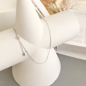 Close-up detail of sterling silver thin chain necklace, minimalist delicate design for daily wear.