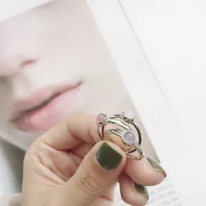 Gros plan de bagues ouvertes délicates en argent sterling S925 ornées de jolies pierres colorées.